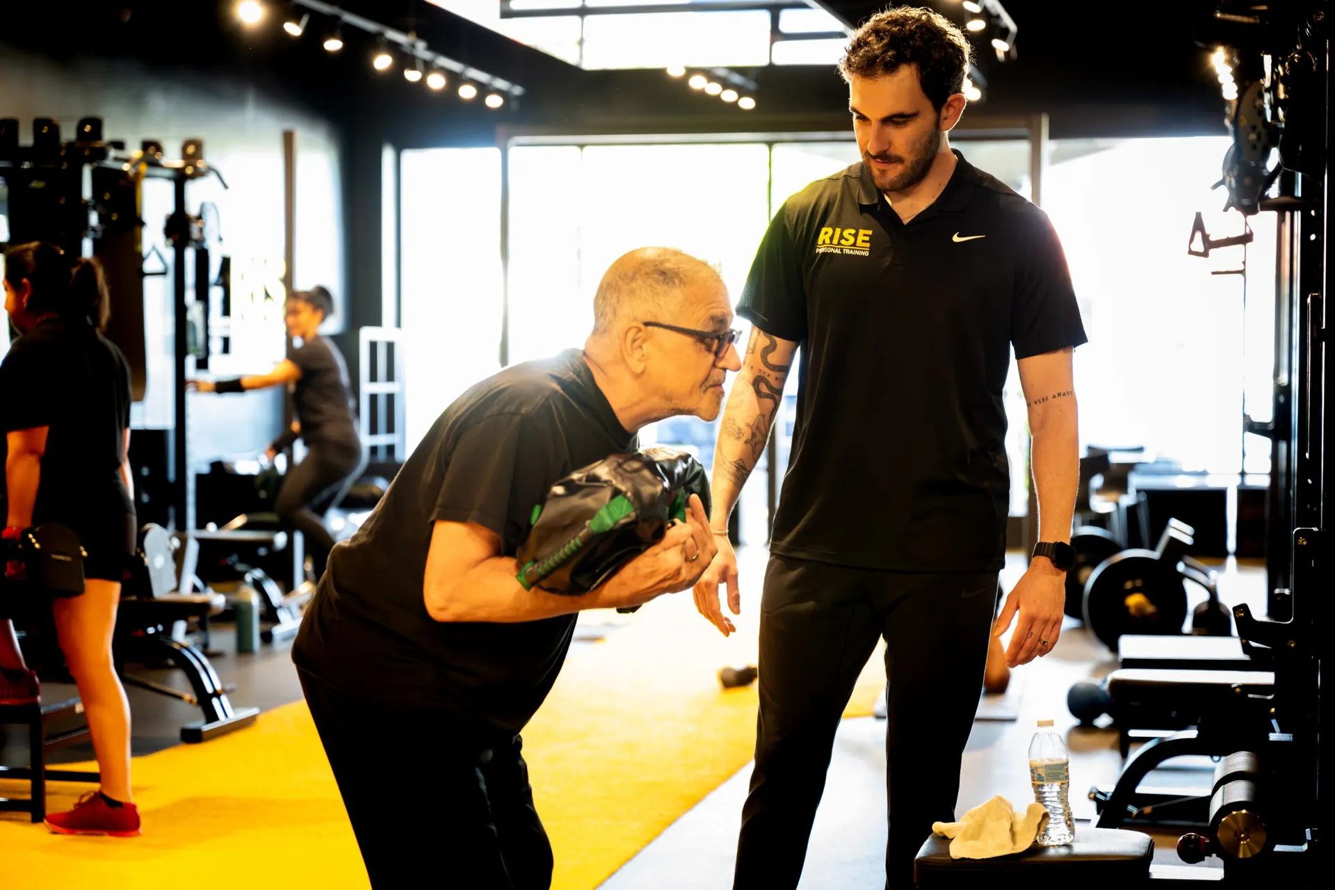Rise coach guiding an older member through a strength exercise in Granada Hills